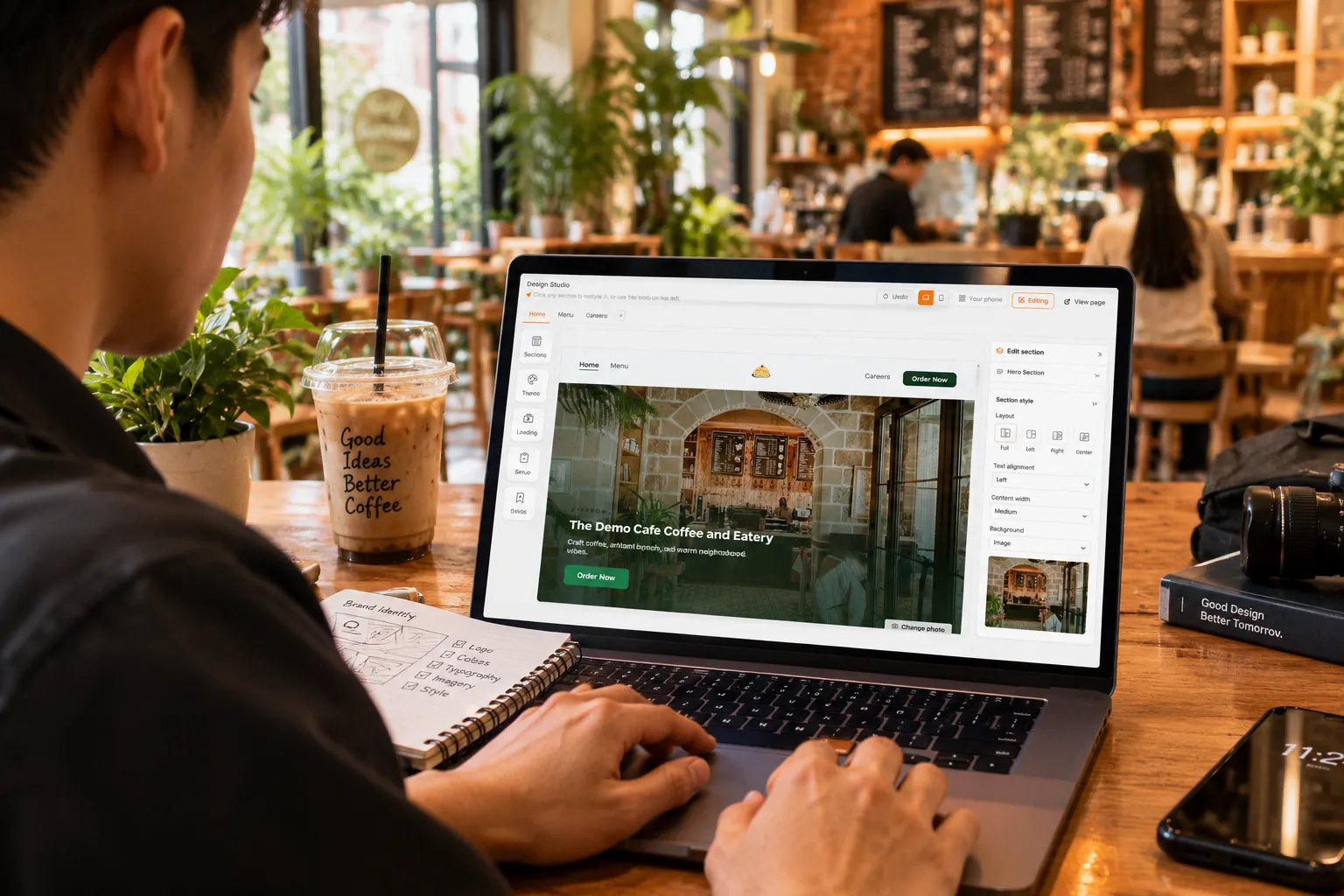 Pemilik kafe mengedit hero website brandnya di Design Studio Qash dari laptop, di meja kafenya sendiri